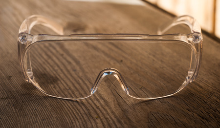 protective transparent plastic glasses on a wooden backgrounの写真素材