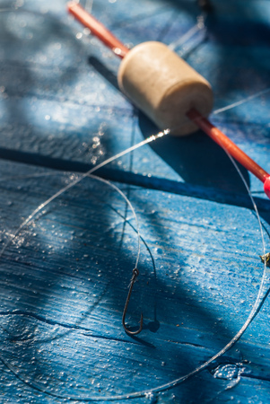 Fishing hook on the fishing line and float on a blue background, hobby fishingの写真素材
