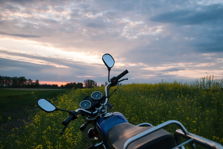 Motorcycle at sunset, rapeseed field, picturesque scenery, adventure time on a motorcycleの写真素材