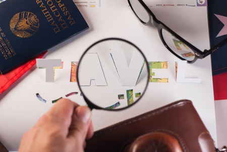 The concept of travel, passport, glasses, magnifying glass,stencil, paper, map of the world on the American flagの写真素材