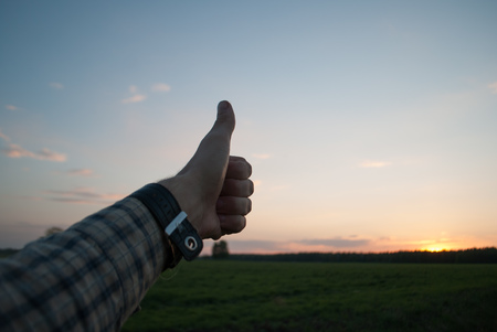 Thumb up on background of sunset, the successful completion of the day, like this dayの写真素材