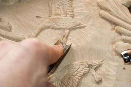 hands of the craftsman carve a bas-relief of wood, tools for wood carving, manual jobの写真素材
