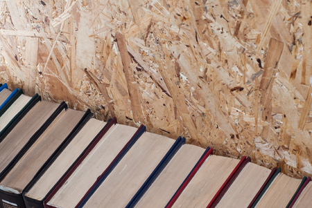 A number of colorful hardcovers on a wooden backgroundの写真素材
