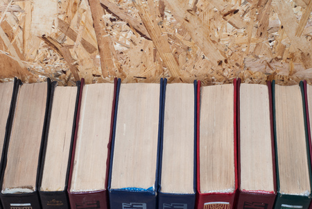 A number of colorful hardcovers on a wooden backgroundの写真素材