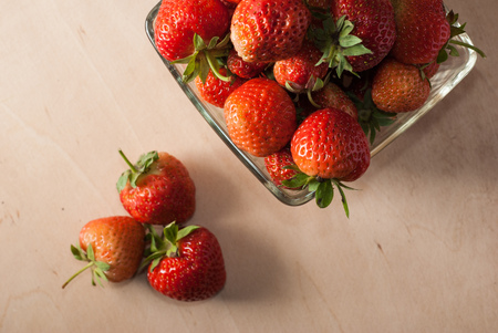 Ripe strawberries in a glass container, wooden background freshly picked berryの写真素材