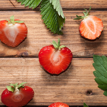 Fresh strawberries on wooden background closeup. Red berry and green leaves. rustic styleの写真素材