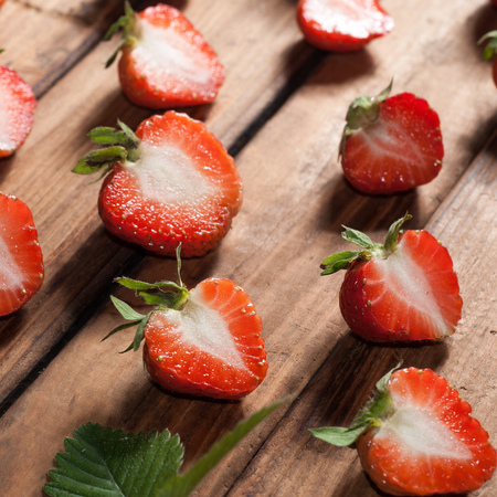 Fresh strawberries on wooden background closeup. Red berry and green leaves. rustic styleの写真素材