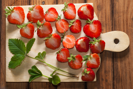 cut the strawberries and leaves on a wooden Boardの写真素材