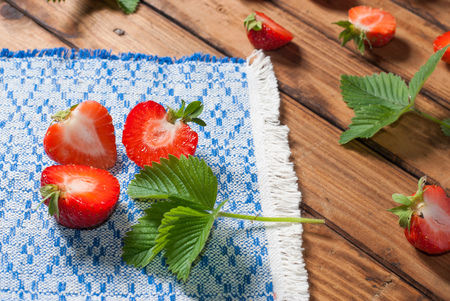 Strawberries closeup. an embroidered cloth.wooden backgroundの写真素材