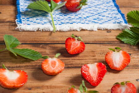 Strawberries closeup. an embroidered cloth.wooden backgroundの写真素材