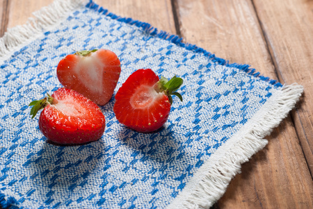 Fresh strawberries on old wooden background, cut berry patterned on a napkinの写真素材