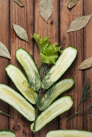 Composition of vegetables on a wooden table. Cucumbers and greens. The view from the top.の写真素材
