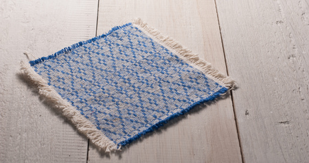 a linen napkin on old wooden table, handmade, patterned embroidery,の写真素材