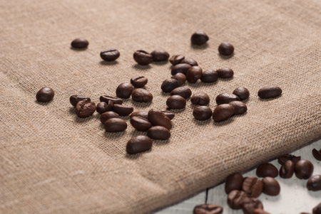 Coffee beans on sackcloth background, the old wooden backgroundの写真素材