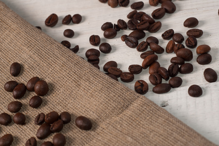 coffee beans on wooden background and rough cloth, top viewの写真素材