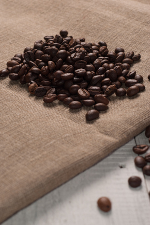 Coffee beans on sackcloth background, the old wooden backgroundの写真素材