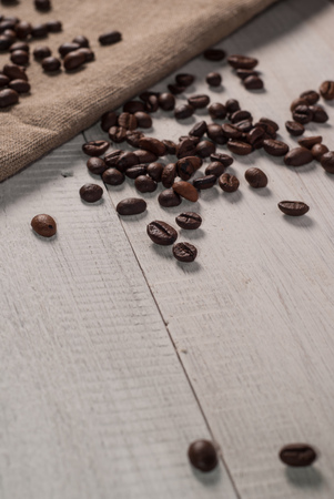 Coffee beans on sackcloth background, the old wooden backgroundの写真素材