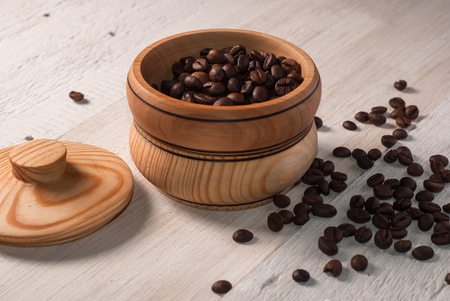 A wooden bowl with coffee beans on old wooden table,の写真素材