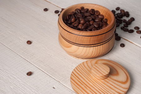 A wooden bowl with coffee beans on old wooden table,の写真素材