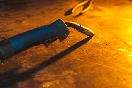Welder, metal table, bright light from the fire in the smithyの写真素材