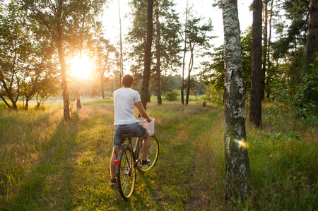 the guy on the bike in the Park, cyclist at sunset, the concept of active restの写真素材