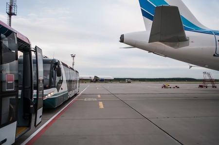 runway, buses , the tail of the plane on sky backgroundの写真素材