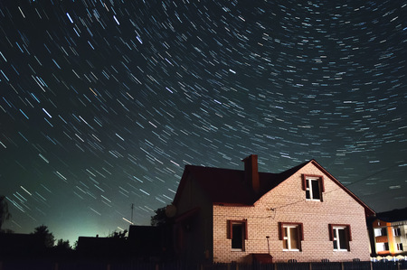 Beautiful starry sky Over the house, star tracks, night sky backgroundの写真素材