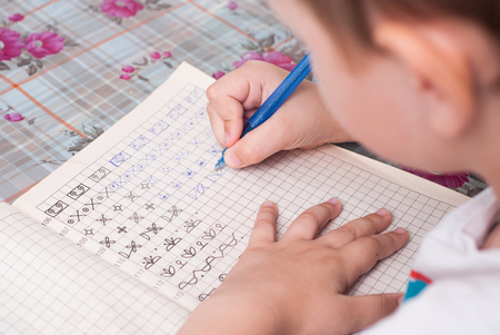 boy doing his homework. the student performs the taskの写真素材