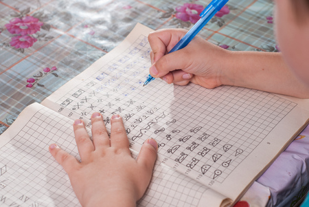 boy doing his homework. the student performs the taskの写真素材