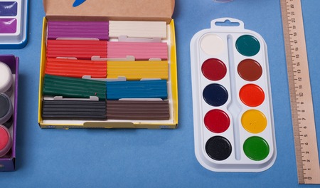 Set for a first grader, clay, paint, ruler on blue background, school supplies, back to schoolの写真素材