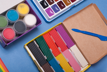 Set for a first grader, clay, paint, ruler on blue background, school supplies, back to schoolの写真素材