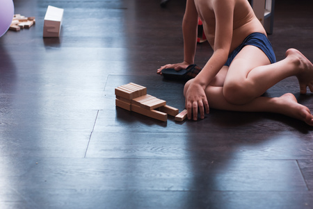 Cute boy builds constructions out of wooden blocks, closeup,の写真素材