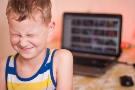 The boy in the background of malicious web pages with prohibited content, the child is horrified by what he saw on the Internetの写真素材