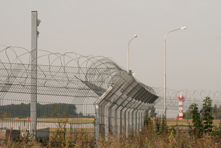 Airport behind a High Fence of Barbed Wire, impassable barrierの写真素材