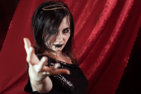 Aggressive woman with Gothic makeup, extending a hand forwardの写真素材