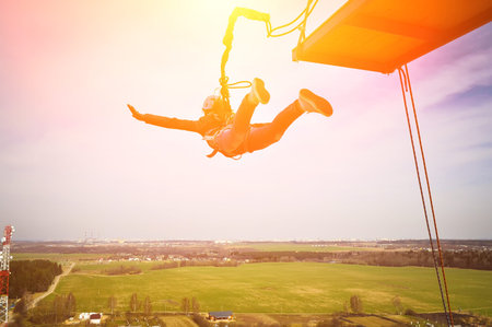 Rope jumping or bungee jumping, girl jumping to the bottom, extreme background