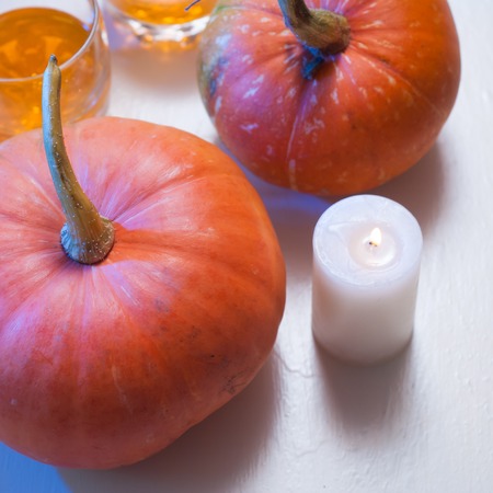 Background with pumpkins and candle on white wooden table with copy spaceの写真素材
