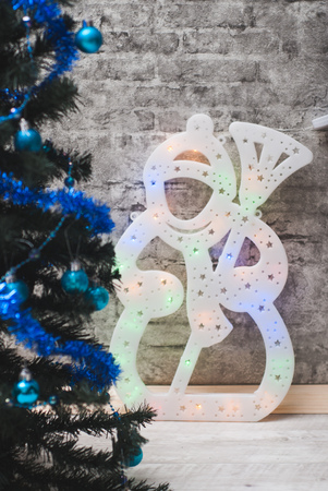 Snowman on the background of the brick wall, Christmas tree in room, Christmas backgroundの写真素材