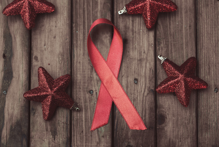 Shiny red satin ribbon on a Christmas table, a symbol of the fight against AIDS, Christmas backgroundの写真素材