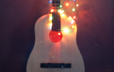 abstract blurred background, an acoustic guitar wrapped in garland Christmas sale of musical instrumentsの写真素材