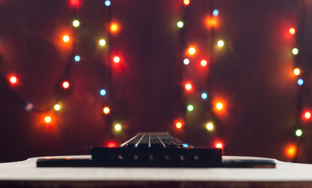 Classic acoustic wooden guitar. selective focus. Christmas bokeh background blurの写真素材