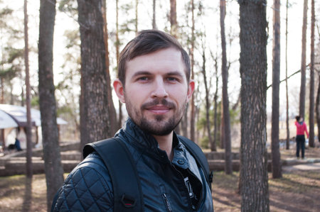 Young good man. funny guy taking selfie in the Park. a bearded hipster in a leather jacketの写真素材