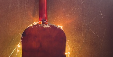 Old acoustic guitar with a garland on grunge background, Christmas sale of musical instruments, guitar, rear viewの写真素材