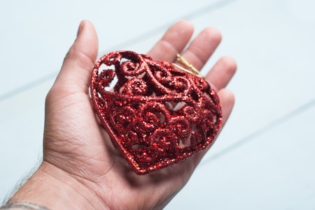 Decorative red heart on the palm, concept proposals hands and hearts, symbol of love and charityの写真素材