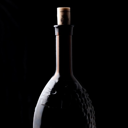 Bottle of red wine on a black backgroundの写真素材