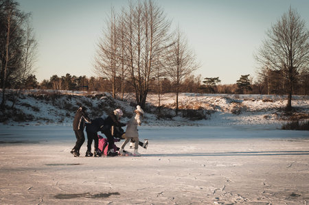 Teenagers frolic on the ice at sunset, winter fun girl skating