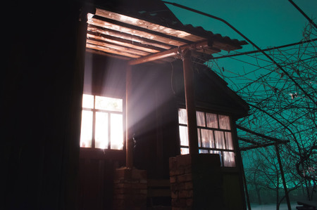 Bright light in the window, strange things happen in a mysterious house, mystical placeの写真素材