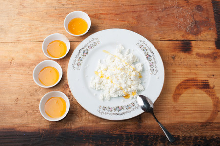 Dietary low calorie cottage cheese with honey, tasty and healthy snack, healthy food, tableware on wooden backgroundの写真素材