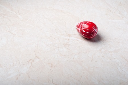 Easter background. Red decorative egg on white marbleの写真素材
