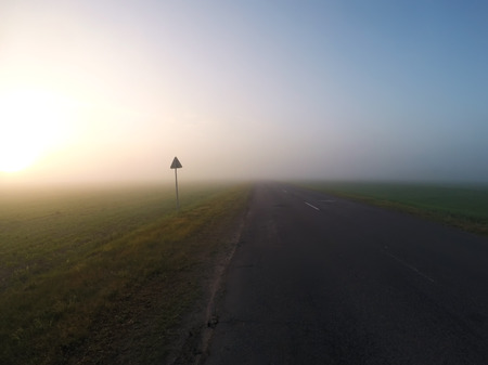Foggy road at dawn, thick fog,の写真素材